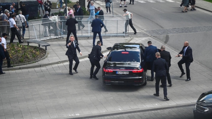 Nhân viên an ninh đưa Thủ tướng Slovakia Robert Fico lên ô tô sau vụ nổ súng ở Handlova, Slovakia, ngày 15/5. Ảnh: Reuters.