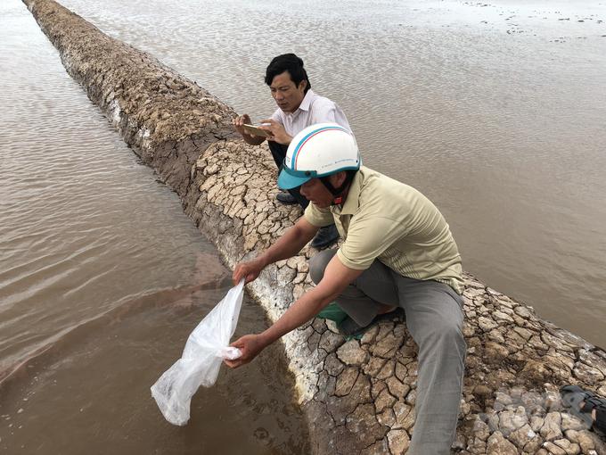 Cán bộ Khuyến nông Bạc Liêu (áo trăng) hỗ trợ kỹ thuật nuôi Artemia cho nông dân. Ảnh: Trọng Linh.