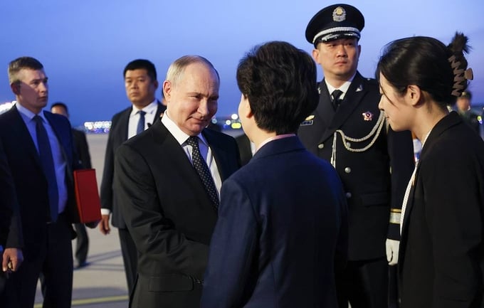 Ủy viên Quốc vụ Trung Quốc Thầm Di Cầm đón Tổng thống Nga Vladimir Putin tại sân bay sáng 16/5. Ảnh: TASS.