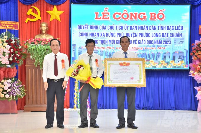 Chủ tịch UBND tỉnh Bạc Liêu Phạm Văn Thiều (bìa trái) trao quyết định công nhận xã Hưng Phú đạt chuẩn xã nông thôn mới kiểu mẫu về giáo dục năm 2023 cho lãnh đạo xã. Ảnh: Trọng Linh. 