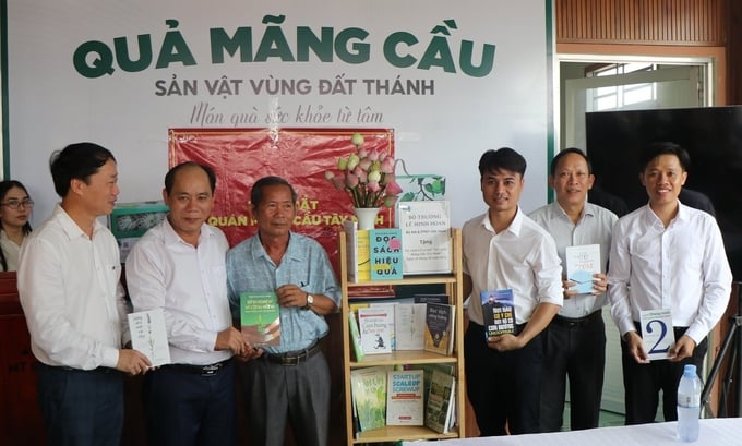 Ông Lê Viết Bình (thứ 2 từ trái sang) thay mặt Bộ trưởng Lê Minh Hoan tặng tủ sách cho Hội quán Mãng cầu Tây Ninh. Ảnh: Trần Trung.