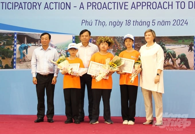 Delegates awarding prizes for the Ring the Golden Bell contest 'Together in Disaster Prevention and Control - Building a Sustainable Future' to participating students. Photo: Trung Quan.