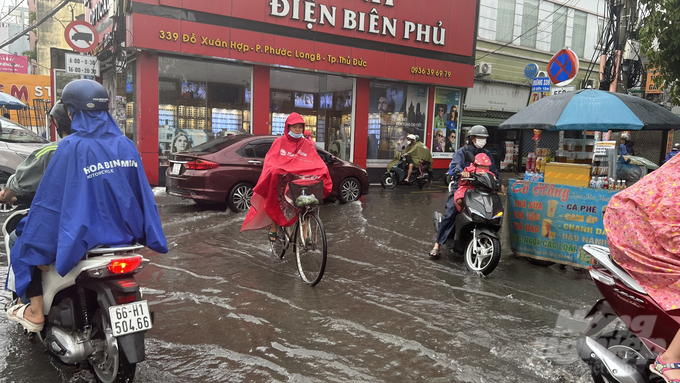 Người dân di chuyển khó khăn sau cơn mưa lớn tại TP Thủ Đức. Ảnh: Trần Phi.