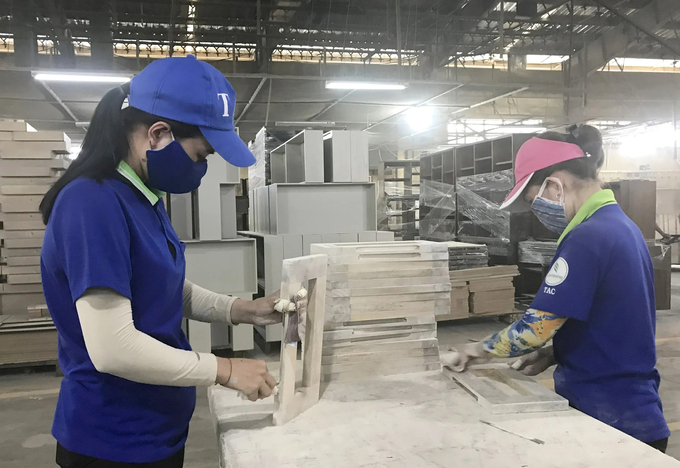 Workers processing wooden furniture for export in Binh Duong province. Photo: Son Trang.