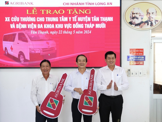 Ông Phan Tấn Luân, Phó Giám đốc Agribank tỉnh Long An (bìa phải) trao tặng xe cứu thương cho Trung tâm Y tế huyện Tân Thạnh và Bệnh viện Đa khoa khu vực Đồng Tháp Mười. Ảnh: Nhật Minh.
