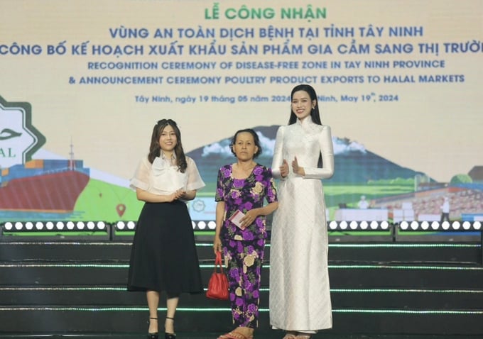 Miss Do Thi Ha and CEO of the DHN Charity Fund Vu Le Dan Thuy presenting a passbook worth 50 million Vietnamese dong to a relative of Heroic Mother Pham Thi Nam.