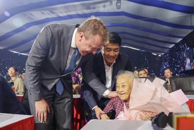 Mr. Johan Van Den Ban - General Director of De Heus Vietnam, Cambodia, Myanmar, India, and Mr. Vu Manh Hung - Chairman of Hung Nhon Group present flowers to Heroic Mother Pham Thi Nam.