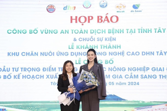 Bà Vũ Lê Đan Thùy, Giám đốc điều hành quỹ DHN, tặng hoa cho Hoa hậu Đỗ Thị Hà, gương mặt đại diện quỹ DHN, trong ngày họp báo 14/5 tại Tây Ninh.