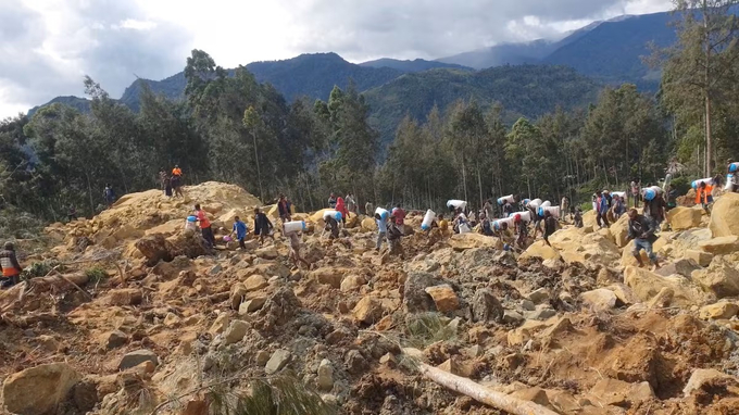 Người dân tìm kiếm người thân sau trận lở đất ở tỉnh Enga, Papua New Guinea, hôm 24/5. Ảnh: Reuters.
