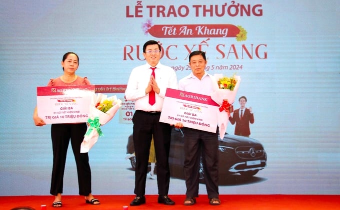 Ông Phan Tấn Luân, Phó Giám đốc Agribank Long An trao giải Ba, mỗi giải là sổ tiết kiệm trị giá 10 triệu đồng cho khách hàng. Ảnh: Minh Khương.