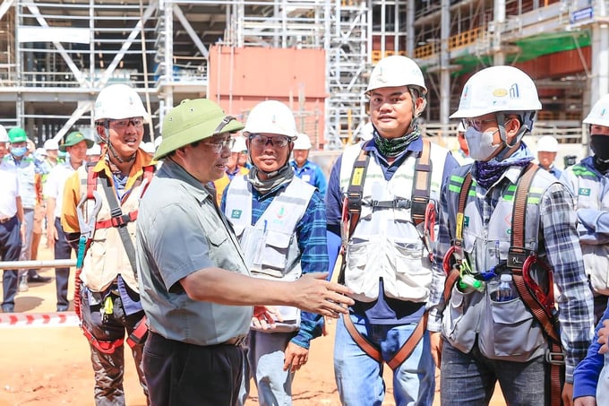 Thủ tướng Phạm Minh Chính thăm hỏi, trò chuyện và động viên kỹ sư, cán bộ, người lao động tại công trường thi công đường dây 500kV mạch 3 Quảng Trạch - Phố Nối (Hưng Yên). Ảnh: TTCP.