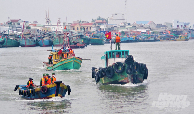 Lực lượng BĐBP tỉnh huy động nhân lực, hướng dẫn cho tàu cá vào khu neo đậu tránh trú bão an toàn. Ảnh: Quang Tiến.