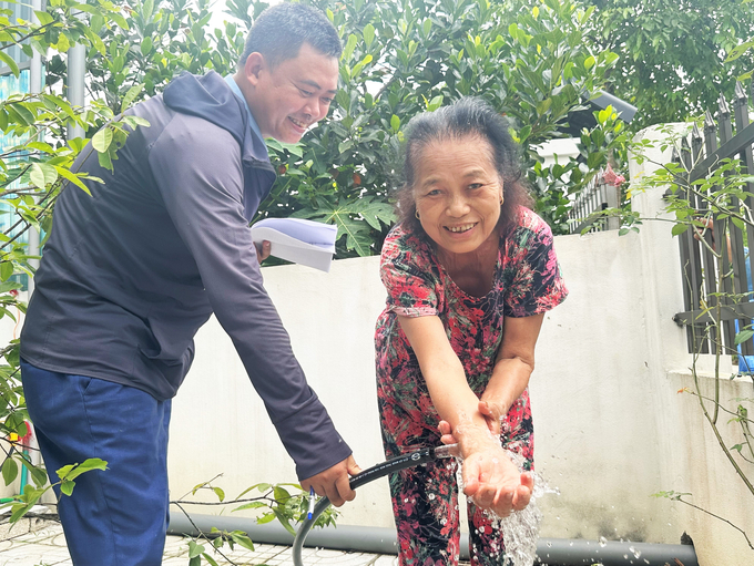 Bà Võ Thị Nhàn, thôn Trung Lộc phấn khởi khi được sử dụng nguồn nước sạch từ công trình cấp nước tập trung. Ảnh: Thanh Nga.