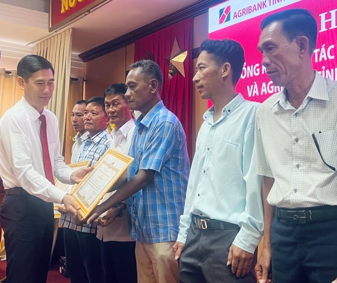 Ông Phan Văn Bá, Phó Trưởng Văn phòng đại diện Agribank khu vực Tây Nam bộ, tặng bằng khen cho các Tổ trưởng Tổ nông dân có thành tích xuất sắc trong công tác phối hợp với Agribank nâng cao chất lượng tín dụng. Ảnh: Minh Khương.
