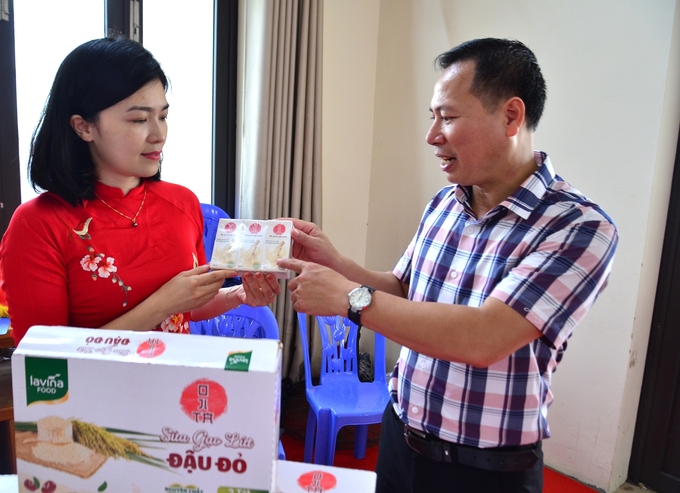 Anh Nguyễn Văn Sự - Giám đốc HTX Nông nghiệp Dân Hòa giới thiệu sữa gạo lứt. Ảnh: Dương Đình Tường.