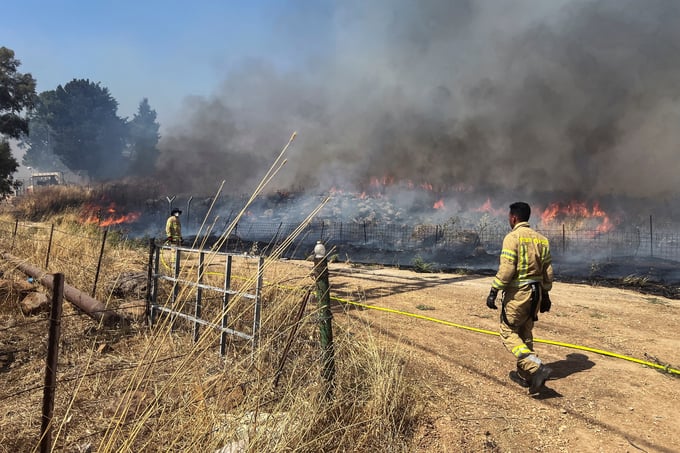 Lực lượng cứu hỏa Israel nỗ lực kiểm soát đám cháy sau các cuộc tấn công bằng tên lửa của Hezbollah hôm 13/6. Ảnh: Reuters.