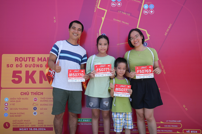 Gia đình bé Khải Lâm đến nhận race kit vào trưa 15/6, cả gia đình sẽ tham gia ở cự ly 5km trong giải chạy Quảng Trị Marathon 2024. Ảnh: Tùng Đinh.