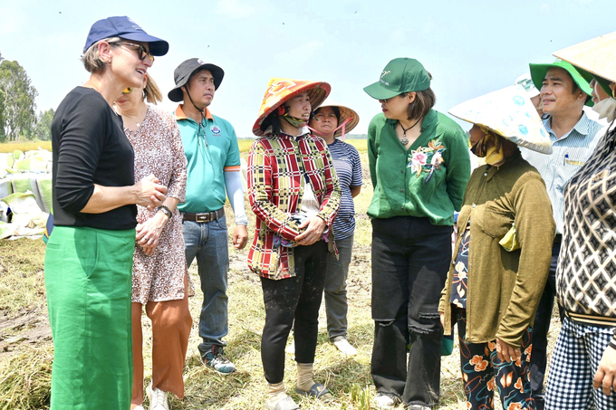 Ms. Le Thi Be Sau (plaid shirt, standing in the middle) shares with the delegation led by Ms. Kristin Tilley, Australian Ambassador for Climate Change - Australian Ministry of Foreign Affairs and Trade, visiting Mr. Nguyen Van Khanh's rice fields.