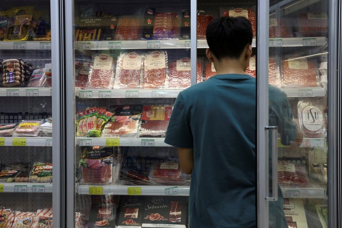 Một nhân viên bày thịt lợn và các sản phẩm từ thịt khác tại một siêu thị ở Bắc Kinh, Trung Quốc. Ảnh: Reuters.