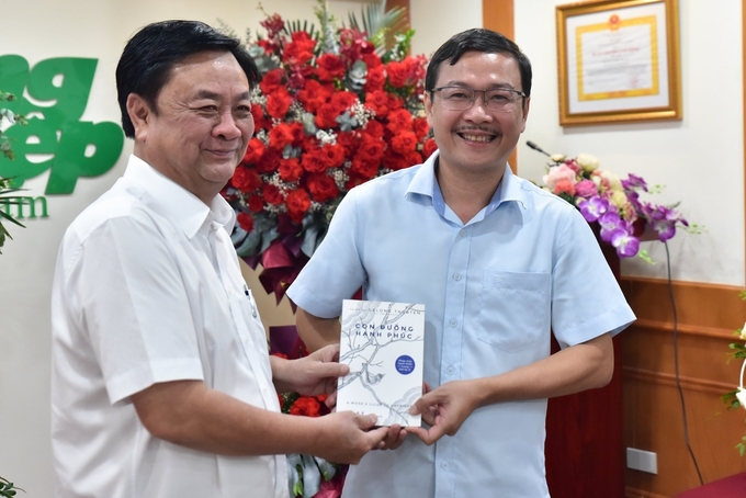 Bộ trưởng Lê Minh Hoan tặng sách cho Tổng Biên tập Báo Nông nghiệp Việt Nam Nguyễn Ngọc Thạch. Ảnh: Tùng Đinh.