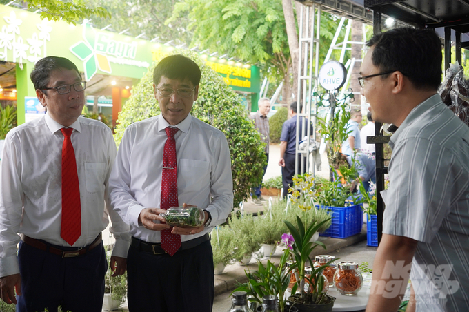 Ông Đinh Minh Hiệp, Giám đốc Sở NN-PTNT TP.HCM (ngoài cùng bên trái) và ông Lê Minh Dũng, Chủ tịch Hội Nông dân TP.HCM (đứng giữa) tham quan gian hàng của Khu Nông nghiệp Công nghệ cao TP.HCM. Ảnh: Nguyễn Thủy.