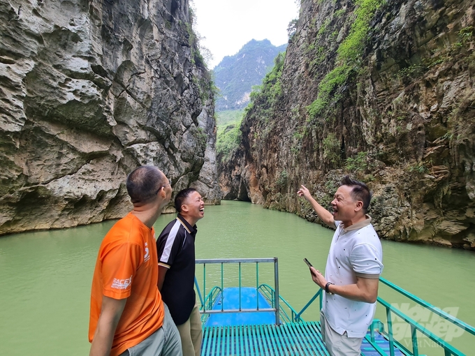 Nhà báo Trần Quốc Doanh (áo cam) và anh Lương Văn Hùng (áo đen) cùng đoàn chúng tôi trên hẻm nhỏ của lòng sông Nho Quế. Ảnh: Đào Thanh.