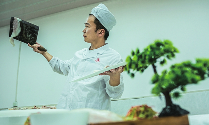 A chef makes a Sliced Pork Belly with Garlic Sauce dish.Photo: VCG