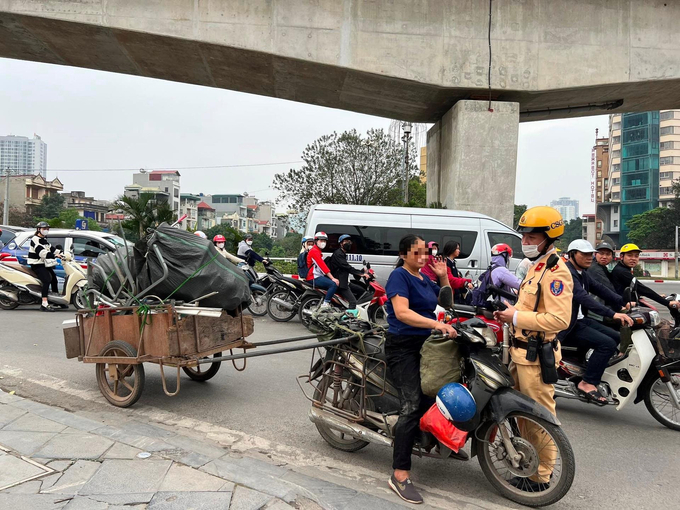 Cảnh sát giao thông xử lý trường hợp xe mô tô kéo theo xe khác chở hàng cồng kềnh tại khu vực cầu Trắng, quận Hà Đông.