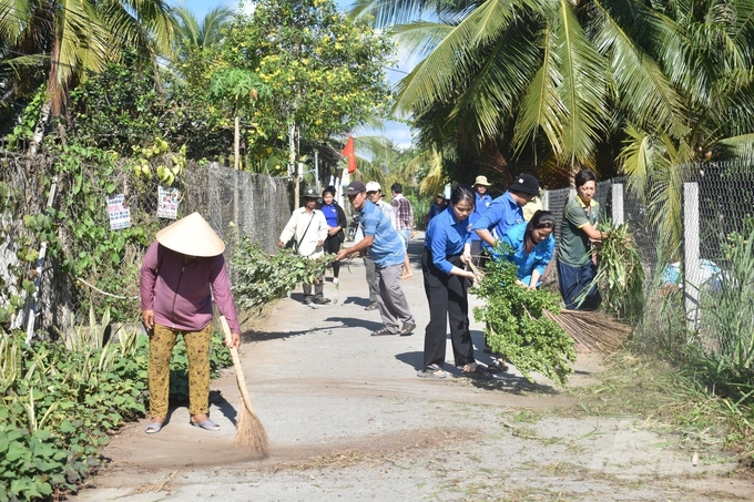 Các bạn đoàn viên thanh niên cùng ra quân dọn dẹp vệ sinh môi trường trong Ngày Chủ nhật nông thôn mới ở Bến Tre. Ảnh: Minh Đãm.