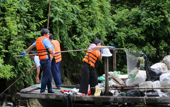 Đại diện lãnh đạo Ban Tuyên giáo Tỉnh ủy thu gom phao xốp, rác thải nhựa trôi nổi trên vịnh.