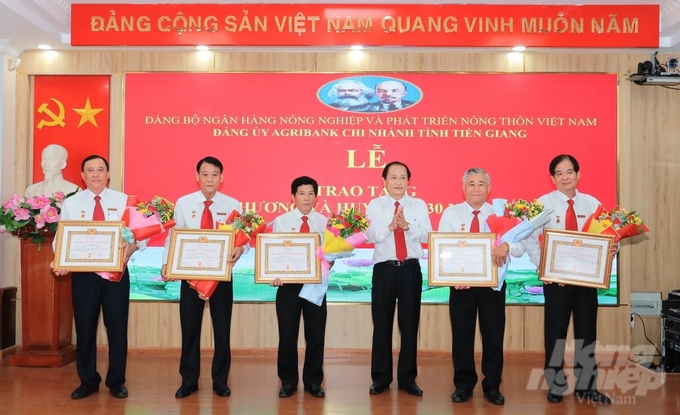 5 đồng chí đảng viên được đồng chí Bí thư Đảng ủy Agribank Tiền Giang Nguyễn Văn Huỳnh trao Huy hiệu 30 năm tuổi Đảng. Ảnh: Quốc Trí.