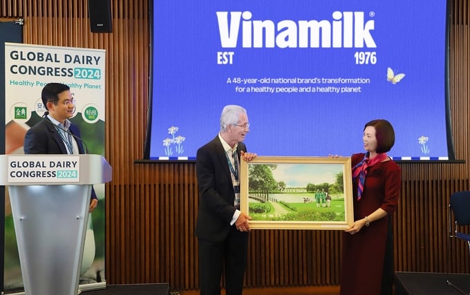 Bà Bùi Thị Hương (bìa phải) - Đại diện Vinamilk trao tặng bức tranh trang trại Green Farm của Vinamilk đến Chủ tịch hội nghị sữa toàn cầu - ông Richard Hall.