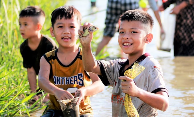 Trẻ em thích thú khi được bố mẹ cho đi trải nghiệm lễ hội bắt cá Vực Rào trong thời gian nghỉ hè.