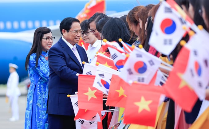 Cán bộ, nhân viên Đại sứ quán và cộng đồng người Việt Nam tại Hàn Quốc chào đón Thủ tướng Phạm Minh Chính và phu nhân. Ảnh: VGP.