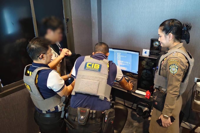 Các sĩ quan cảnh sát kiểm tra máy tính trong cuộc đột kích vào nhà của một người đàn ông 36 tuổi, chủ sở hữu một trang Facebook quảng cáo cá độ bóng đá, ở Nakhon Ratchasima hôm 21/6. Ảnh: Bangkok Post.
