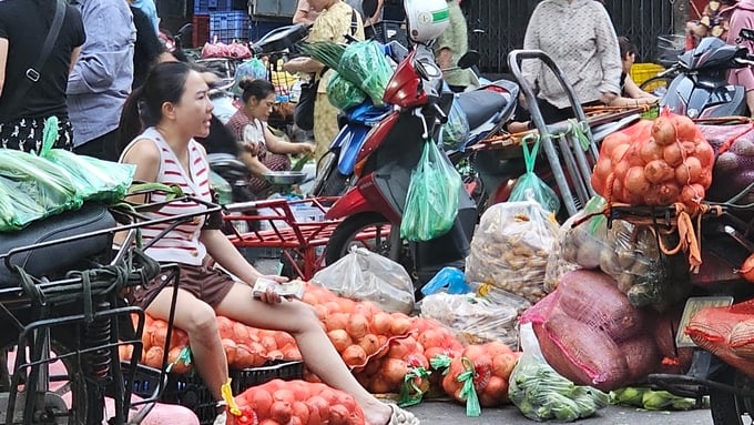 Bà Hoàng Thị Bích Nguyệt, chủ Công ty TNHH dịch vụ nấu ăn số 1 Vĩnh Phúc, mua thực phẩm không rõ nguồn gốc ở chợ tạm. Ảnh: Văn Việt. 