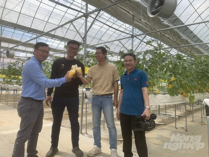 Dr. Park DooHo, the founder (second from the right), invites guests to enjoy fresh melons produced at the farm. Photo: Hai Tien.