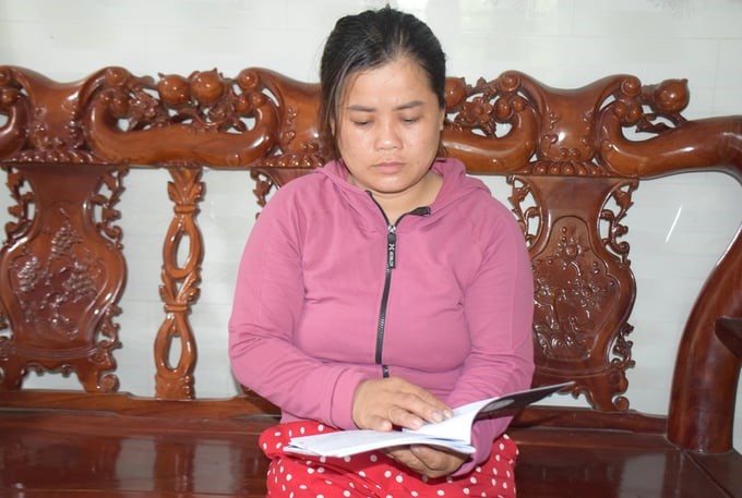Ms. Dang Thi Nu looked back at the documents related to her family's asset, which is the fishing vessel BD 31224 TS confiscated by Malaysia, with regret. Photo: V.D.T.