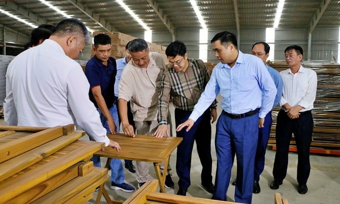 Deputy Minister Nguyen Quoc Tri visits a forest product processing and export facility.