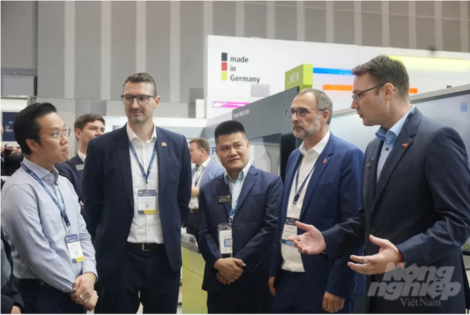Dr. Ha Minh Hiep, the Deputy General Director in charge of the General Department of Metrology, Ministry of Science and Technology (farthest left in the image), is exchanging information with the enterprises participating in the exhibition. Photo: Nguyen Thuy.