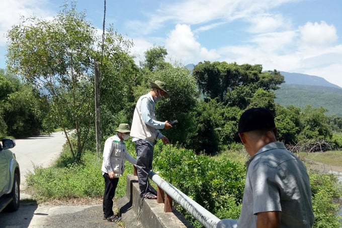 Cán bộ Sở Tài nguyên và Môi trường tỉnh Thừa Thiên - Huế lấy mẫu nước xác định nguyên nhân cá chết. Ảnh: CĐ.