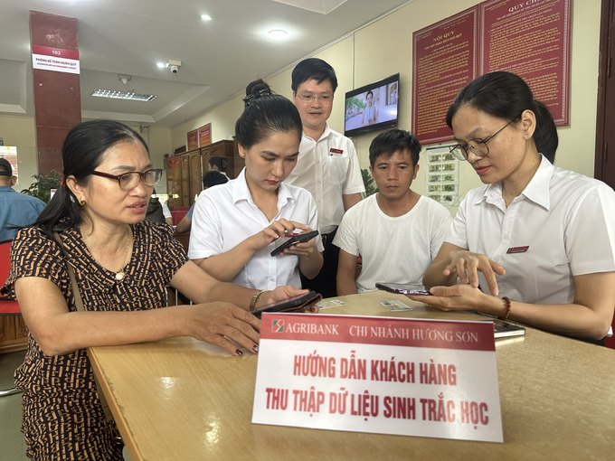 Ban lãnh đạo và giao dịch viên Agribank chi nhánh huyện Hương Sơn trực tiếp hỗ trợ khách hàng thu thập sinh trắc học tại quầy. Ảnh: TN.