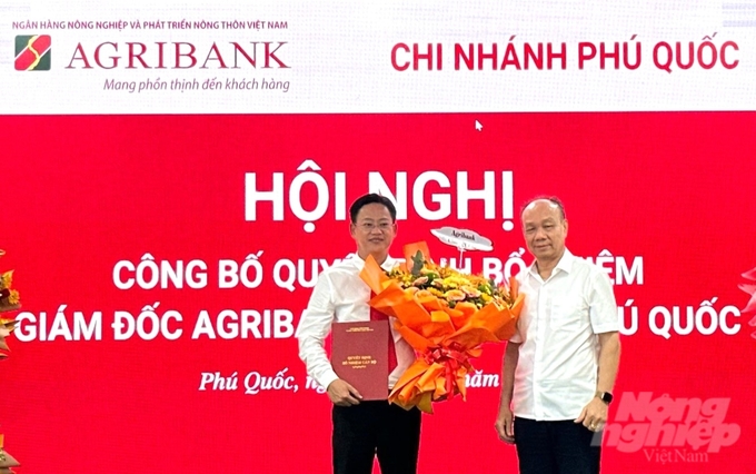 Ông Nguyễn Minh Trí, Thành viên HĐTV Agribank trao quyết định chúc mừng ông Tiêu Tường Phục nhận nhiệm vụ mới. Ảnh: Thanh Hà.