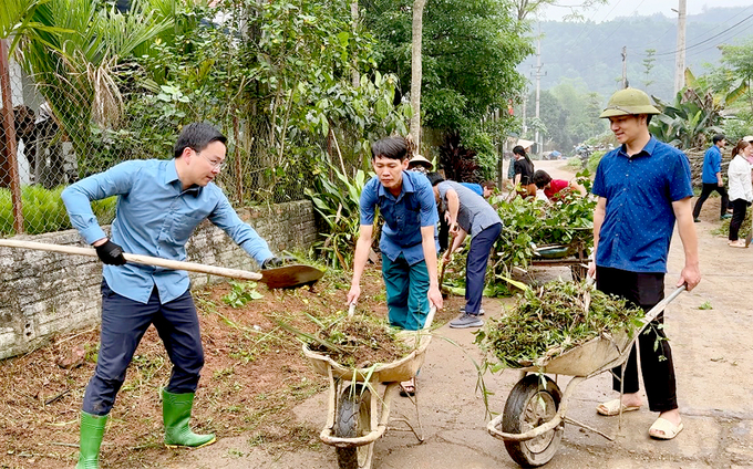 Bí thư Huyện ủy Yên Bình An Hoàng Linh (ngoài cùng bên trái) tham gia lao động vệ sinh môi trường cùng người dân.