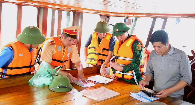 Lực lượng chức năng thành phố Hạ Long kiểm tra thủ tục hành chính, lập biên bản tạm giữ tàu cá neo đậu không đúng nơi quy định. Ảnh: Cường Vũ.