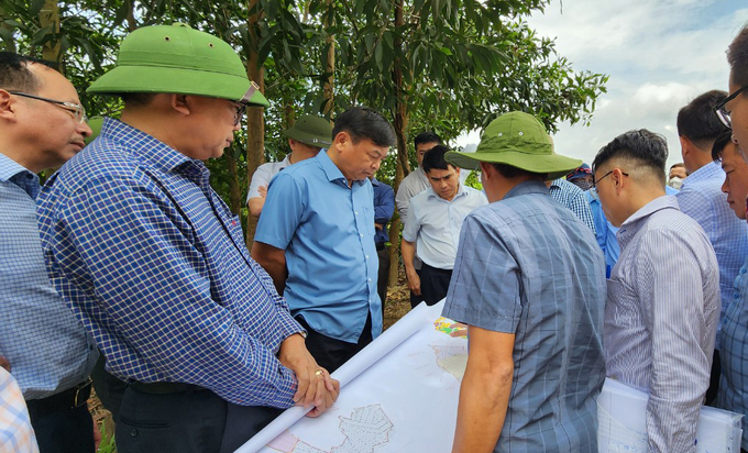 Thứ trưởng Nguyễn Hoàng Hiệp đi kiểm tra thực địa tại khu tái định cư số 2 của dự án hồ Krông Pách Thượng. Ảnh: Quang Yên.