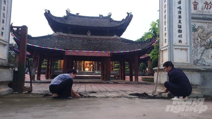 Mr. Bui Van Vy and Ms. Chu Thi Loc, two elderly members of Hoi Phu village, cleaned up the historical and cultural relic of Hoi Phu Communal House - Pagoda. Photo: Kien Trung.