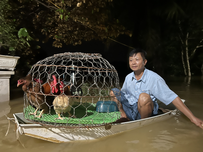 Người dân xã Tốt Động, huyện Chương Mỹ dùng thuyền để sdi chuyển tài sản trong đêm. Ảnh: Hùng Khang.