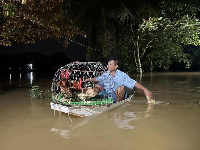 Để bảo vệ tài sản, người dân phải dùng thuyền di chuyển. Ảnh: Hùng Khang.