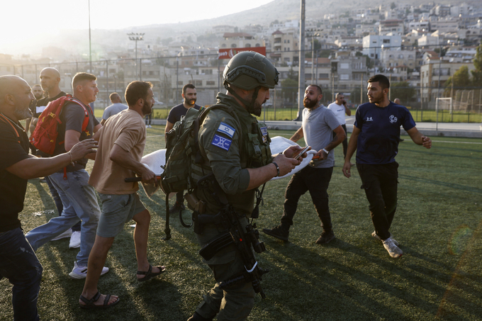 Nhân viên y tế Israel đưa những người bị thương đi điều trị sau khi một quả tên lửa từ Lebanon rơi trúng sân bóng đá ở thị trấn Majdal Shams ở Cao nguyên Golan hôm 27/7. Ảnh: AFP.